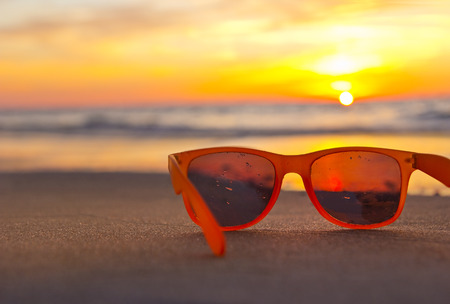 sunglasses on the beach while sunset