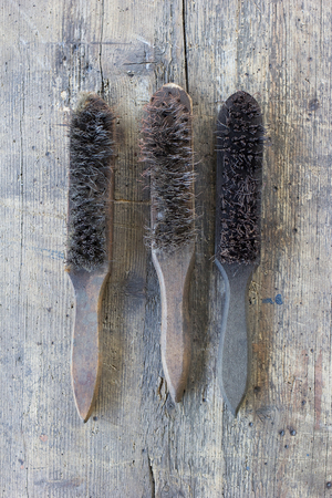 Old, dirty wire brushes against wooden plank. Tool series.の写真素材
