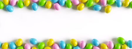 Colorful easter eggs border on white background with a large copy space. 3D render illustration.の写真素材