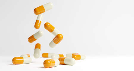 Yellow and white medical capsules falling down on the blue background. 3D render. 3D illustration.の写真素材