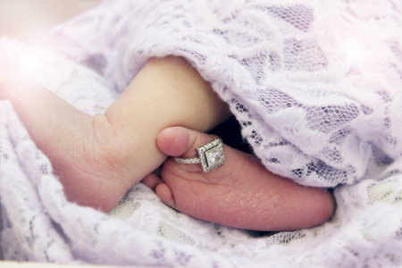 Baby foot with an engagement ring on toeの写真素材
