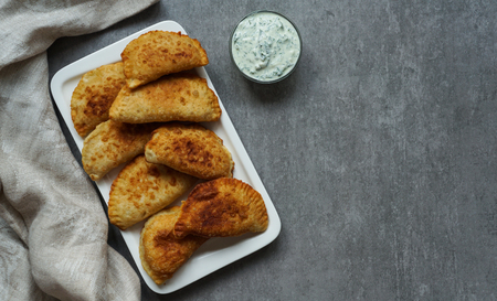 Spanish and Latin American fried empanadas with sauce on the grey stone background, top viewの写真素材