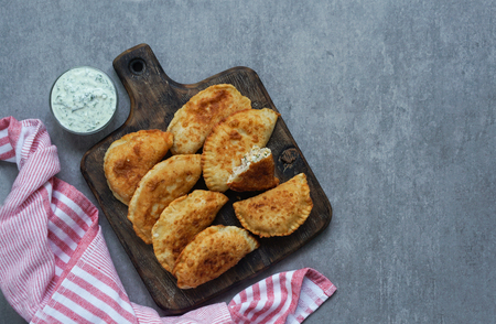 Spanish and Latin American fried empanadas with sauce on the grey stone background, top viewの写真素材