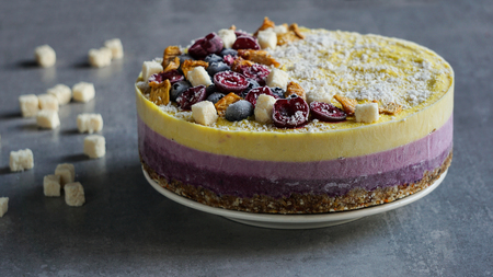 Raw vegan berry and mango cheesecake gluten-free on a white wooden background, coconutの写真素材