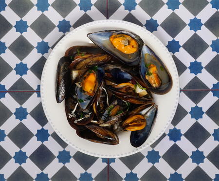 Traditional spanish seafood mussels on the mediterranean ceramic background. Top view, copyspace. Square cropの写真素材