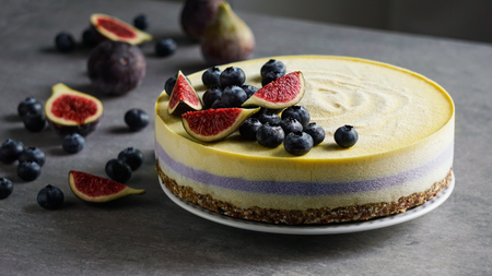 Vegan raw cheesecake with blueberry and figs, cashew cream, coconut butter and coconut milk, and base made of almonds, dates and dried apricots, oat flakes, lyophilisated berryの写真素材