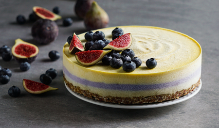 Vegan raw cheesecake with blueberry and figs, cashew cream, coconut butter and coconut milk, and base made of almonds, dates and dried apricots, oat flakes, lyophilisated berryの写真素材