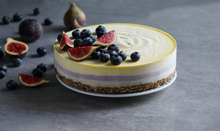 Vegan raw cheesecake with blueberry and figs, cashew cream, coconut butter and coconut milk, and base made of almonds, dates and dried apricots, oat flakes, lyophilisated berryの写真素材