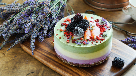 Vegan raw cheesecake with blueberry, cherry, matcha tea, orange,  cashew cream, coconut butter and coconut milk, and base made of almonds, dates  and  dried apricots, oat flakes, lyophilisated berryの写真素材