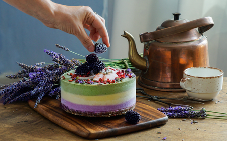 Vegan raw cheesecake with blueberry, cherry, matcha tea, orange,  cashew cream, coconut butter and coconut milk, and base made of almonds, dates  and  dried apricots, oat flakes, lyophilisated berryの写真素材