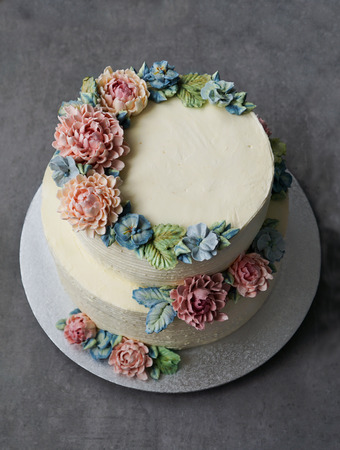 big wedding cake, decorated with buttercream flowers, on the grey stone backgroundの写真素材