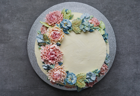 big wedding cake, decorated with buttercream flowers, on the grey stone backgroundの写真素材