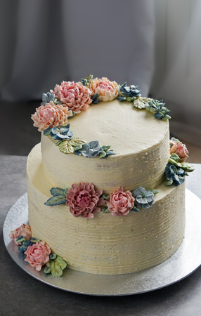 big wedding cake, decorated with buttercream flowers, on the grey stone backgroundの写真素材