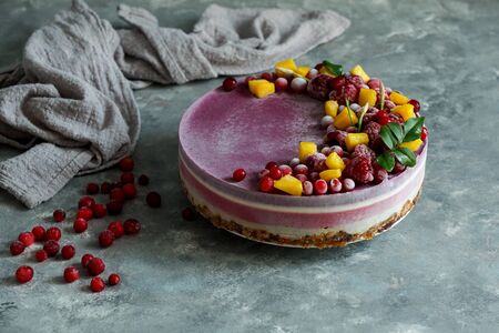 Vegan raw cheesecake with blueberry, cherry, matcha tea, orange,  cashew cream, coconut butter and coconut milk, and base made of almonds, dates  and  dried apricots, oat flakes, lyophilisated berryの写真素材