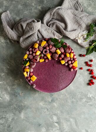 Vegan raw cheesecake with blueberry, cherry, matcha tea, orange,  cashew cream, coconut butter and coconut milk, and base made of almonds, dates  and  dried apricots, oat flakes, lyophilisated berryの写真素材