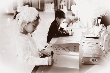 CHINA NANCHANG February 26, 2015: Two kids signing on book in the wedding partyのeditorial素材