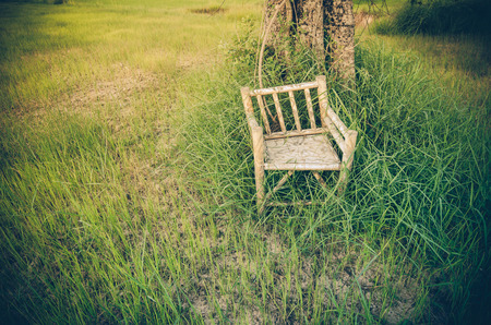 Bamboo wooden chairs on grass field in countryside Thailand vintageの写真素材