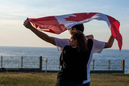 Celebrating Canada Day flag on nature background couple in love