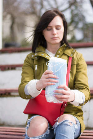 Brunette woman thinks about protection during a pandemic medical masks to protectの写真素材