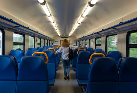 Rear view of a girl, the view from the back, walking along the train carriage, the seats are visibleの写真素材