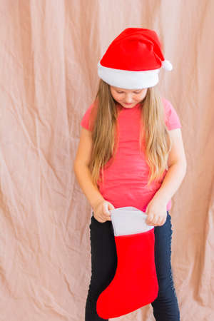 Girl celebrates new year and christmas wearing santa claus hat with christmas sock