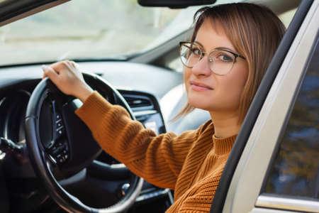Confident young business woman in the new car