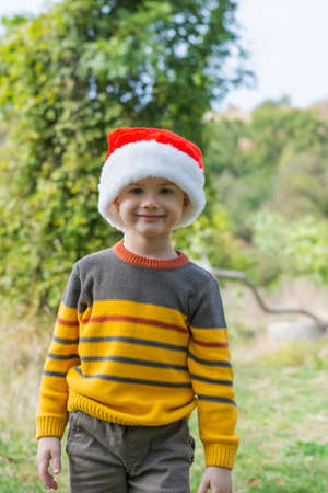 Boy wearing Santa hat exploring outdoorsの写真素材