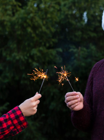 Christmas sparkler burning focus on fireworks on the street near the Christmas trees