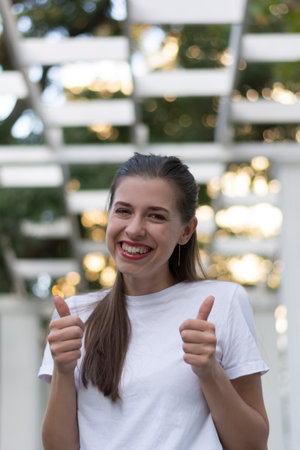 Joyful smiling woman showing victory approving thumbs up ok happy for success winner gestureの写真素材