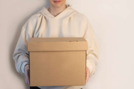 Recycler craft box in woman hands mockup place for text and design on beige background