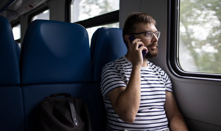 Handsome man talking on phone in the carriageの写真素材