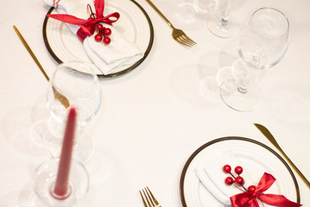 Christmas holiday table setting on white background with golden, red decorationsの写真素材