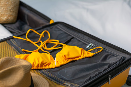 Close-up of an open suitcase with swimwear for relaxing by the ocean or a tropical beachの写真素材