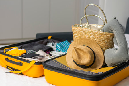 Yellow open suitcase lies on the bed in white room copy space mockupの写真素材