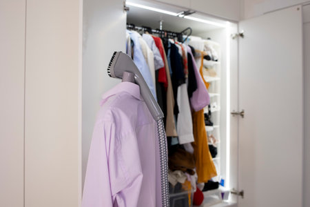 steamer handle on the background of an open fashionable wardrobe closetの写真素材