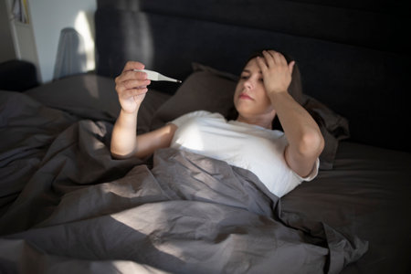 Woman lying on sofa in her home with high feverの写真素材