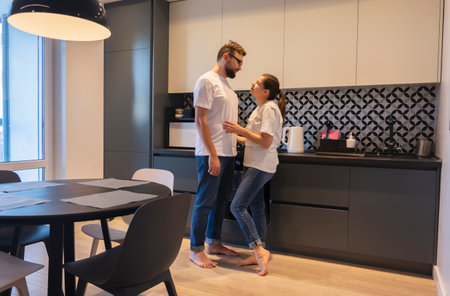 Young couple hugging at home in the kitchen relationship marriage life togetherの写真素材
