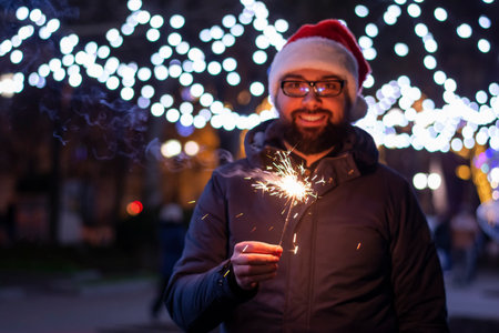 Happy young Man in santa hats sparklers on christmas eveの写真素材