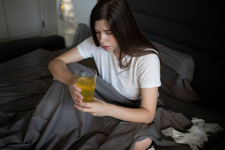 Woman takes her temperature during a flu illness treatmentの写真素材