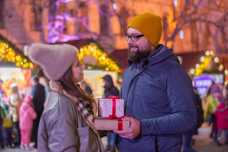 Cheerful young woman receiving a gift from her boyfriendの写真素材
