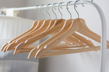 Wooden coat hangers on clothes railの写真素材