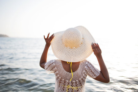 Woman in white hat at the beachの写真素材
