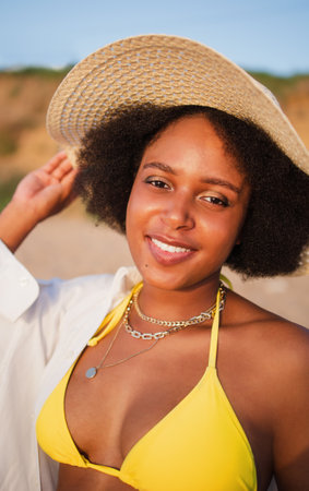 Smiling young woman in beachwear enjoying the sunset on the beachの写真素材