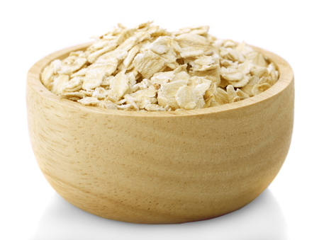 Oat flakes in bowl and wooden isolated on white backgroundの写真素材