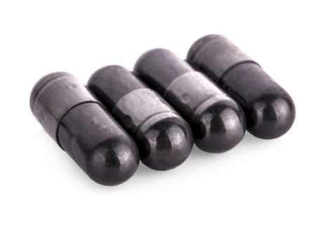 Charcoal capsules isolated on whiteの写真素材