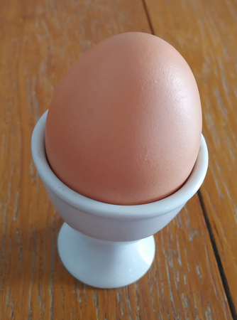 Close-up view of raw chicken eggs on white wooden background