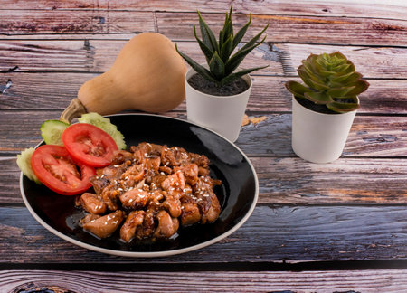 Caramelized teriyaki chicken with sesame seeds in a bowlの写真素材