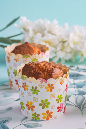 Muffin in spring conception white, blue, pink and green colors, spring flowers, scandic background