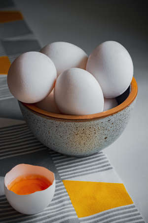 ceramic bowl of eggs is on the tableの写真素材