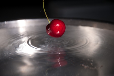 Red cherry drop into waterの写真素材